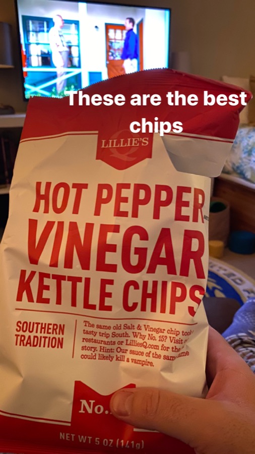 Instagram story from September 2020: a hand holding a bag of Hot Pepper Vinegar Kettle Chips in front of the TV, captioned "These are the best chips"
